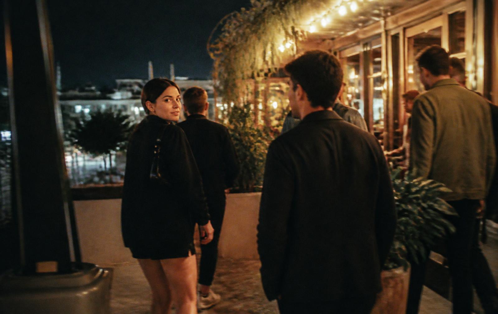 Friends leaving a rooftop restaurant at night
